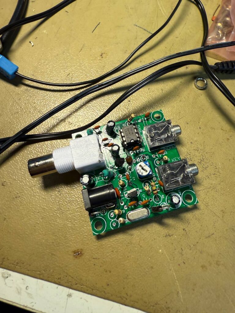 Small green board with lots of components mounted on top of it. You can see two small jack connectors and one large white one.